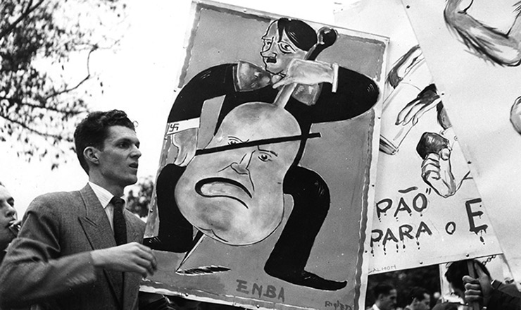  <strong> Cartaz satirizando Hitler, </strong> criado na Escola Nacional de Belas-Artes, é carregado por estante durante manifestação pró-Aliados no Rio
