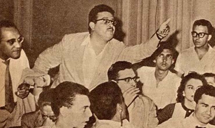  <strong> O poeta paulista Haroldo Campos investe contra</strong> os acusadores do concretismo, secundado pelo crítico Oliveira Bastos (paletó na mão), na Noite de Arte Concreta, realizada no salão da UNE em 1957