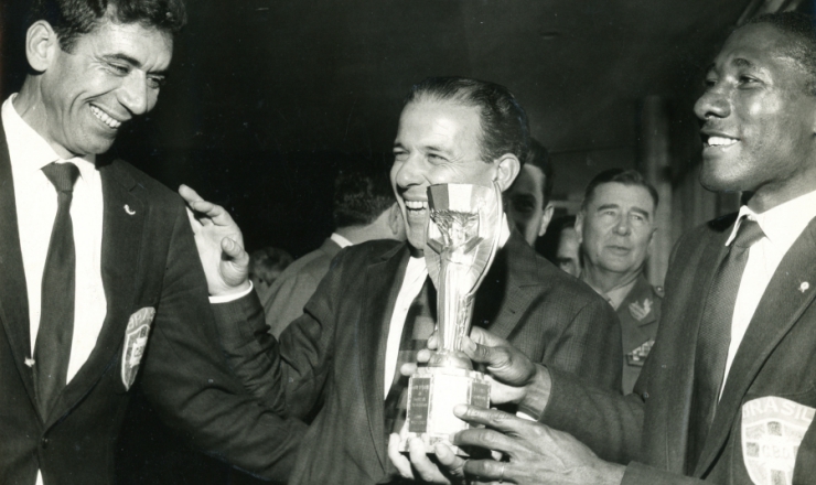  <strong> Entre Nilton Santos e Djalma Santos e com a taça Jules Rimet na mão, Jango recebe </strong> a Seleção Brasileira bicampeã do mundo