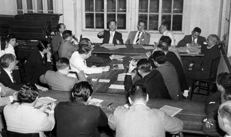       <strong> Hermes Lima</strong> (1º, de óculos, terno escuro) e outros durante reunião do jornal “Vanguarda Socialista”, órgão do Partido Socialista Brasileiro 