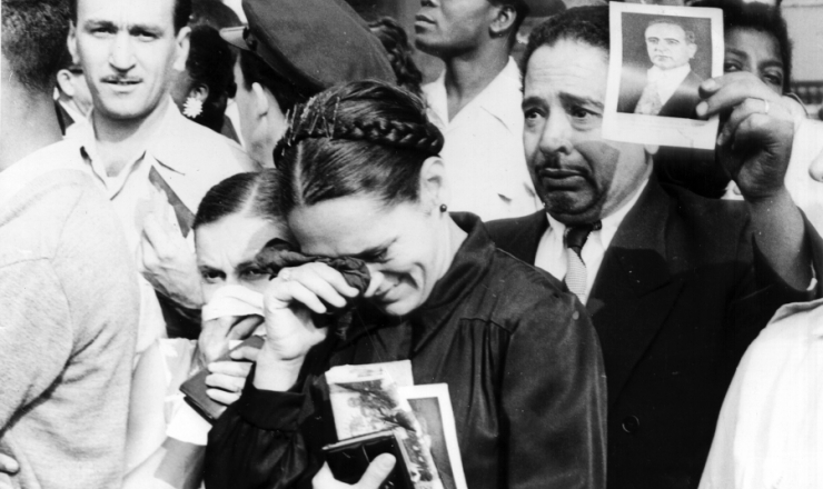       <strong> Populares mostram </strong> com orgulho a foto de Getúlio Vargas durante a passagem do cortejo fúnebre na capital federal 