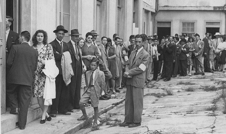       <strong> Fiscal observa fila de eleitores </strong> que aguardam para votar nas eleições de 1947, em São Paulo