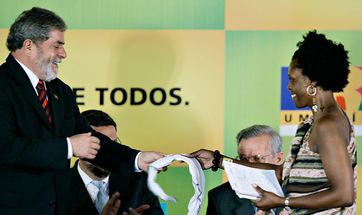 <strong> Solange Aparecida Ferreira de Campos, bolsista do ProUni para curso de gastronomia, entrega </strong> uma faixa da organização Educafro ao presidente Lula