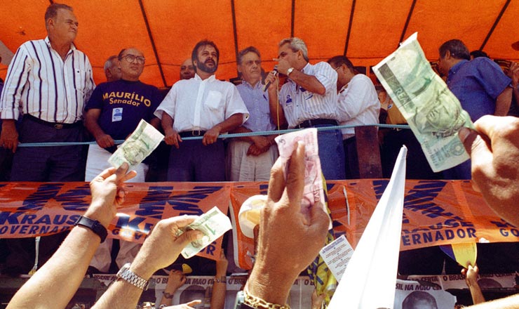  <strong> Em campanha em Pernambuco, </strong> populares saúdam Fernando Henrique Cardoso acenando com notas de real, nova moeda que trouxe estabilidade econômica   