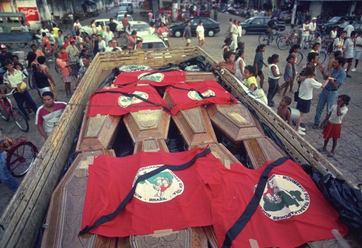  <strong> Caixões dos mortos no massacre </strong> de sem-terras levados para enterro cobertos por bandeiras do MST   